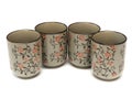 Four clay cups with red floral engraving design Royalty Free Stock Photo