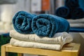 Four clean soft double bath towels set of different colors stacked, lying on wooden chair