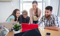 Four co-workers watching a business presentation in a modern shared office Royalty Free Stock Photo