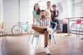 Four co-workers wearing casual clothes during work in a modern h