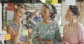 Four colleagues collaborating in office, with glass board sketches, sticky notes and tablet device Royalty Free Stock Photo