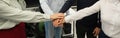 Four colleagues give the low five in the office. Close-up of the hands of office workers.