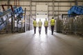 Four colleagues in reflective vests leaving a warehouse Royalty Free Stock Photo