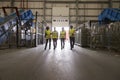 Four colleagues walking into a warehouse, wide view