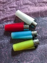Four colored lighters, blue,red,yellow and white on a cloth