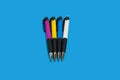 four colored pens on blue background. office accessories Royalty Free Stock Photo