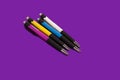 Four colored pens lying on a purple background Royalty Free Stock Photo