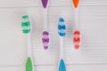 Four colored tooth brushes on white wooden table. Royalty Free Stock Photo