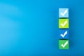 Four colorful checkmarks against bright blue background with copy space
