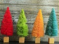 Four colorful  Christmas trees on rustic wood Royalty Free Stock Photo