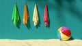 Four colorful fluffy towels hanging on the turquoise brick-like wall with a beach ball on sand, symbolizes vacations, holidays