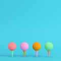 Four colorful golf balls with tee on bright blue background in pastel colors. Minimalism concept