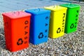 Four colorful recycling bins