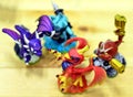 Four colorful toy dragons appear in a game of fighting.