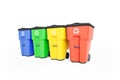 Four colorfull plastic garbage bins with recycling logo, staked on row.