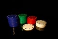 Four colors casino chips stack with a white chip in front,  on black with reflection Royalty Free Stock Photo