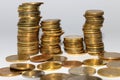 four columns of coins lined up on top of each other and a few coins around them on a white background Royalty Free Stock Photo