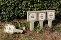 Four concrete signs by the roadside for sluice valve and washout hydrant. One is broken and has fallen over