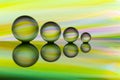 Four crystal balls in a row with colorful streaks of rainbow color behind them Royalty Free Stock Photo