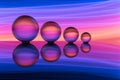 Four crystal balls in a row with colorful streaks of rainbow color behind them Royalty Free Stock Photo