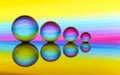 Four crystal balls in a row with colorful streaks of rainbow color behind them Royalty Free Stock Photo