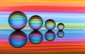 Four crystal balls in a row with colorful streaks of rainbow color behind them Royalty Free Stock Photo