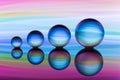 Four crystal balls in a row with colorful streaks of rainbow color behind them Royalty Free Stock Photo