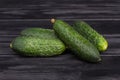 Four cucumbers on wood.