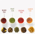 Four cups of tea on white table with large assortment of herbal, flower, berry and leaf dry teas