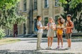 Cute multicultural schoolkids talking while standing in schoolyard and holding books