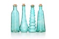 Four cyan colored glass bottles of different shapes