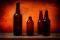 Four dark brown glass beer bottles on a barn wood table in front of an orange background Royalty Free Stock Photo
