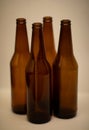 Four dark empty glass beer bottles.