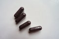 Four dark purple capsules of bilberry extract
