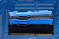 Four DDR memory chips in different colors lying on a blue printed circuit board. Royalty Free Stock Photo