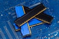 Four DDR memory chips in different colors lying on a blue printed circuit board. Royalty Free Stock Photo