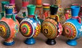 Four decorated colorful handcrafted pottery jugs on sackcloth ba Royalty Free Stock Photo