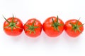 Four delicious ripe red tomatoes on white background lie in a row. Royalty Free Stock Photo