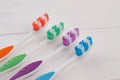 Four different tooth brushes on wooden background. Royalty Free Stock Photo