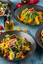 Four different types of salads served freshly on blue stone table