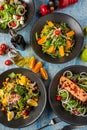 Four different types of salads served freshly on blue stone table