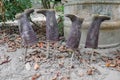 Four dirty rubber boots drying upside down on wood posts, worker and farmer boots