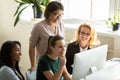 Four diverse businesswomen thinking in negotiations looking at computer screen.