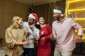 Four diverse friends at New Year& x27;s party celebrating and dancing, house guests having fun at Christmas, in New Royalty Free Stock Photo