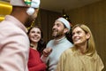 Four diverse friends at New Year's party celebrating and dancing, house guests having fun at Christmas, in New Royalty Free Stock Photo