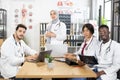 Diverse doctors sitting at conference room with gadgets Royalty Free Stock Photo