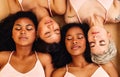 Four diverse women lying on background