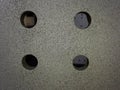 four Drilled holes over a blasted clean grey steel surface