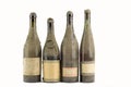 Four dusty bottles of old italian wine lined on white backgrou Royalty Free Stock Photo