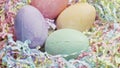 Four Easter color eggs in pastel color confetti background.